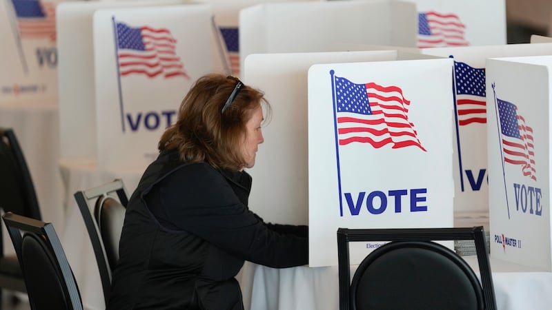FILE - A voter fills out her ballot for the Michigan primary election in Grosse Pointe Farms,...