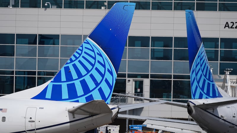 FILE - The company logo adorns the tail sections of United Airlines jetliners as they taxi to...